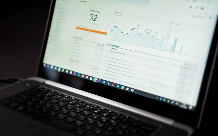Een laptop met een dashboard vol cijfers en grafieken, sfeerbeeld bij de Fluxdesk demo