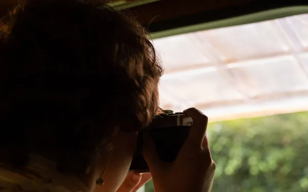 Een fotografe die door haar camera kijkt, sfeerbeeld bij de Lise Verhoeven demo
