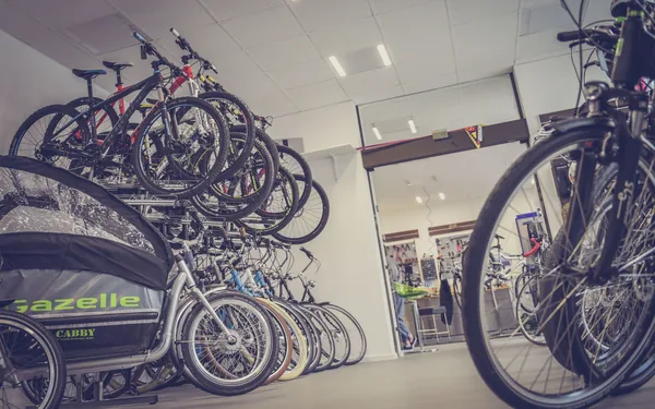 Een fietsenwinkel van binnen, fietsen in de rekken en de werkplaats achteraan, sfeerbeeld bij de demo van Fietsen Vandael