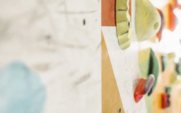 Gekleurde klimgrepen op een boulderwand, sfeerbeeld bij de Verticaal demo