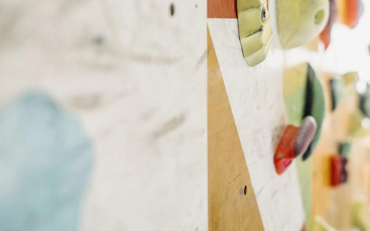 Gekleurde klimgrepen op een boulderwand, sfeerbeeld bij de Verticaal demo